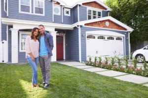 Couple standing in front of house